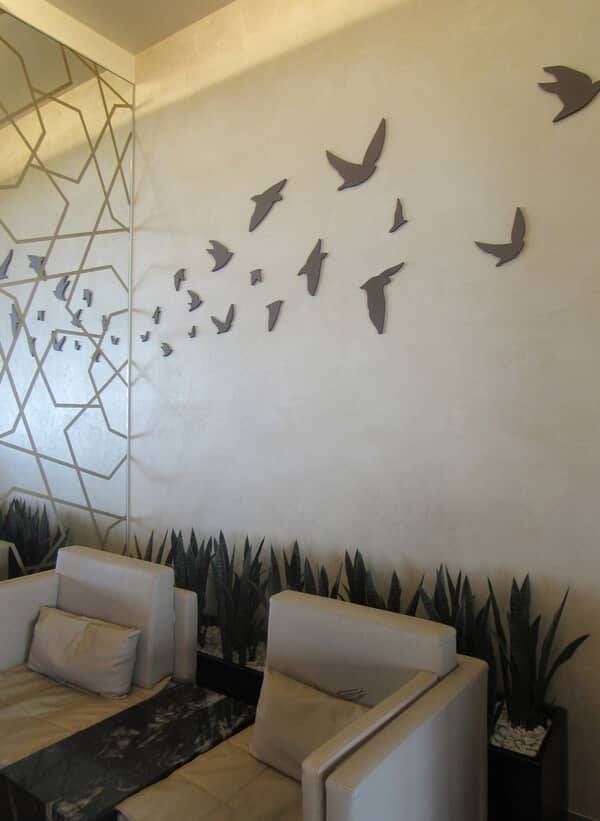 Lounge seating against a lime plaster wall with a fretwork screen and bird motif