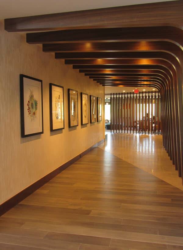 Gallery corridor with timber ribs and a striated ornamental plaster wall