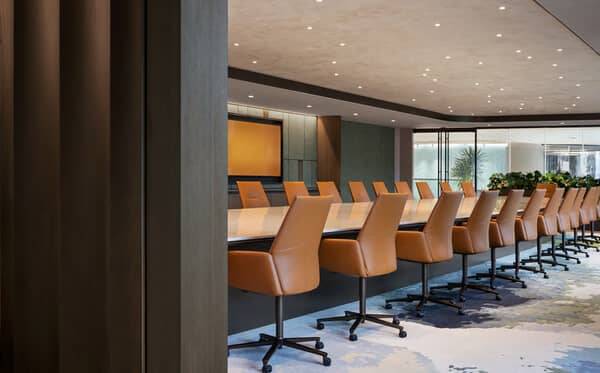 Boardroom with a long conference table against a seamless plaster wall