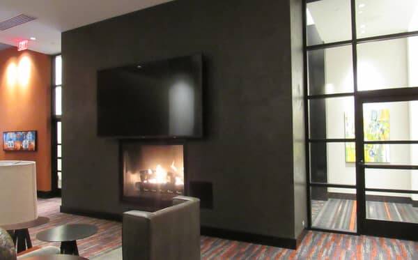 Lounge fireplace with a plaster chimney breast under a mounted screen
