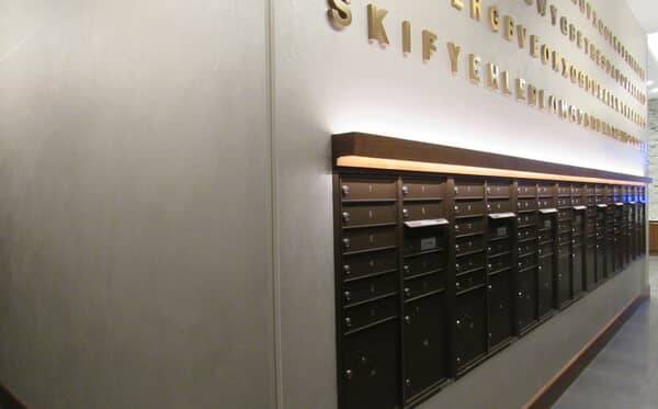 Residential mail room with a plaster-finished wall carrying the building name