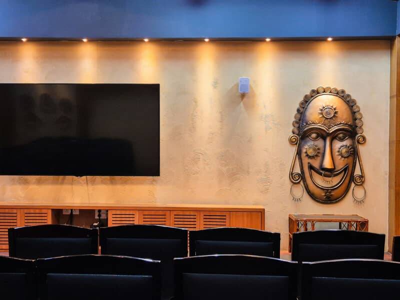 Boardroom feature wall in decorative plaster with a carved mask and integrated joinery