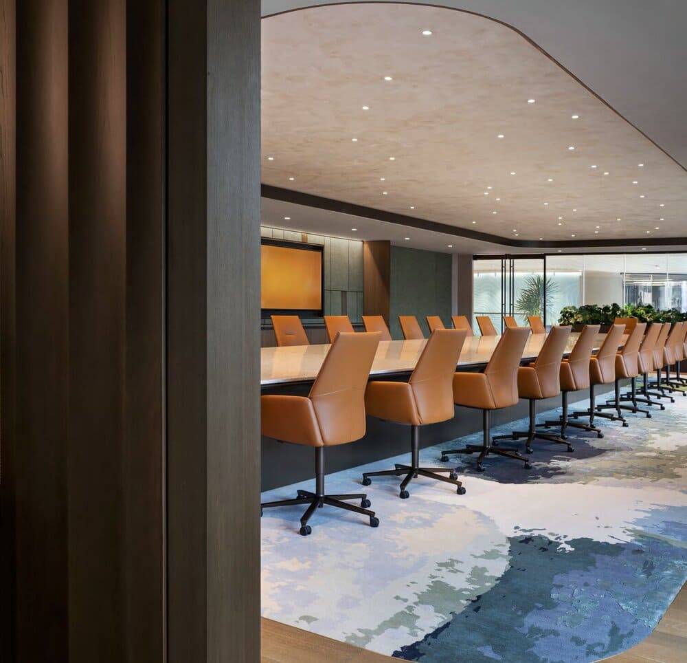 Boardroom with a long conference table against a seamless plaster wall