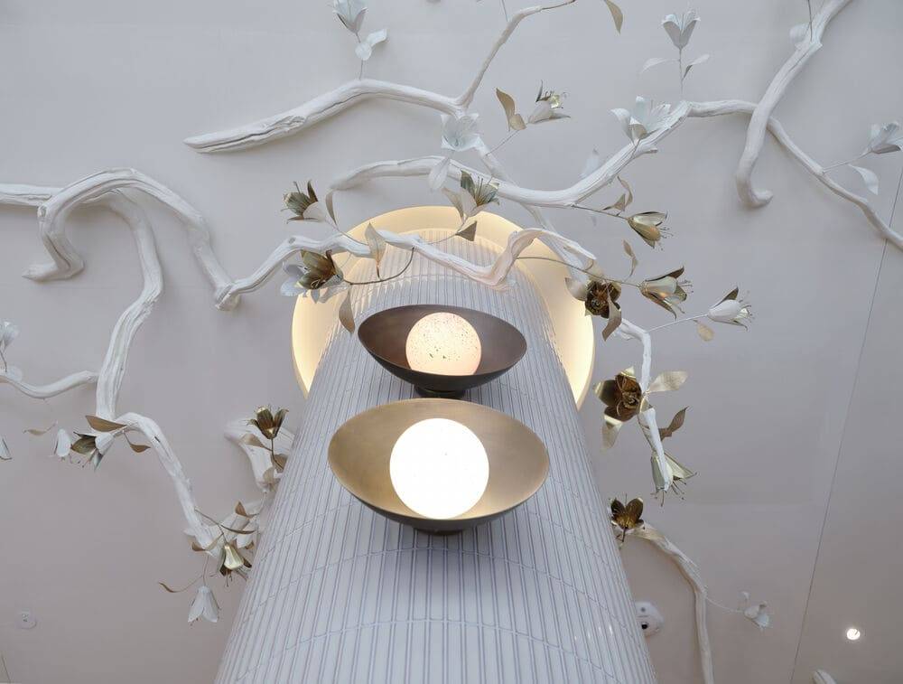 Sculptural plaster ceiling with branching relief around pendant lights