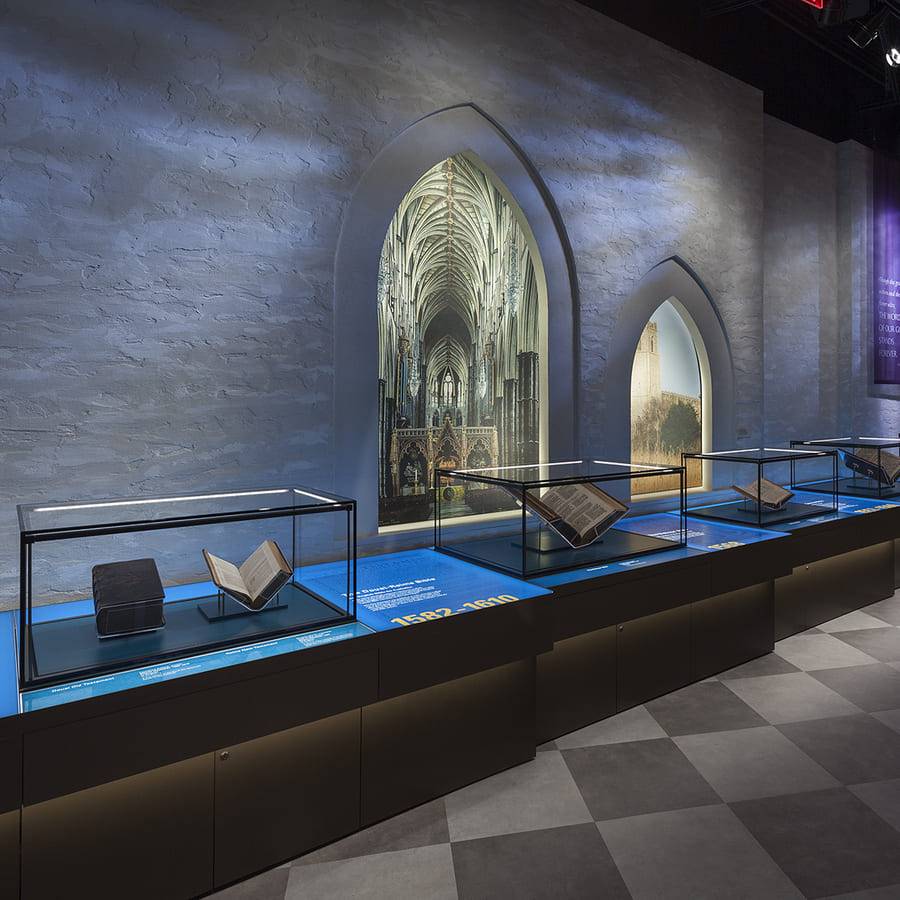 The Bible Museum gallery with plaster stone-effect walls above lit display cases