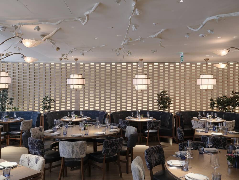 Hotel restaurant beneath a slatted vaulted ceiling finished in acoustic plaster