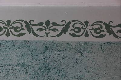 Green floral stencil on grey plaster