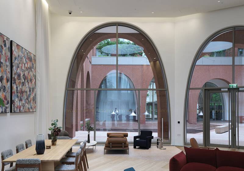Hotel lounge with full-height plaster walls framing arched windows